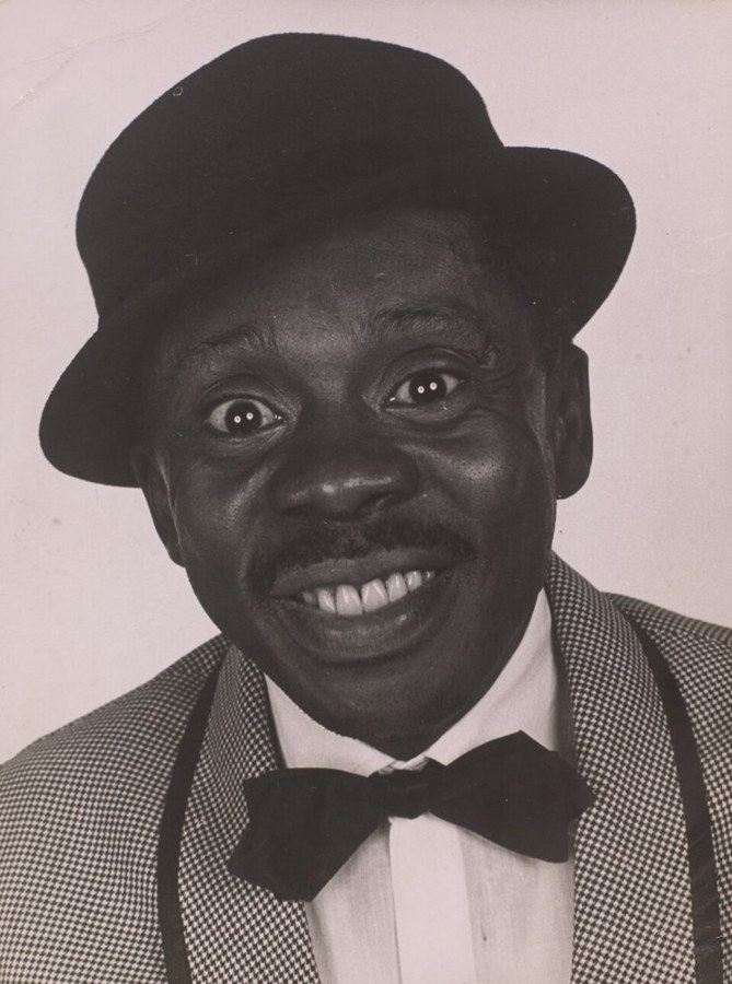 Grande Otelo de chapéu-coco, gravata-borboleta e paletó xadrez